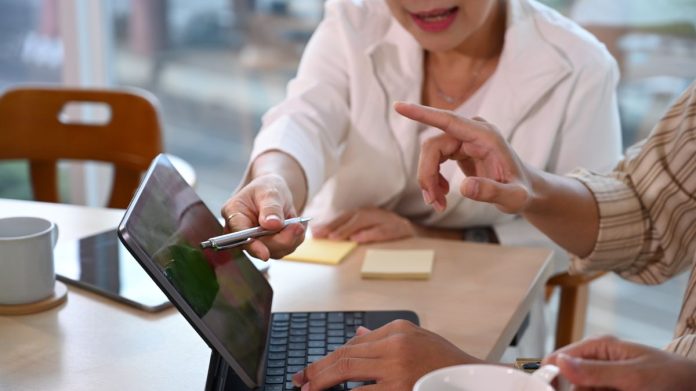 două persoane discutând despre cumulul de funcții și gestionarea contractelor de muncă multiple în reges online și despre câte contracte de muncă poate avea un salariat
